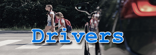 Drivers - sideview of vehicle with two children walking holding hands in foreground 